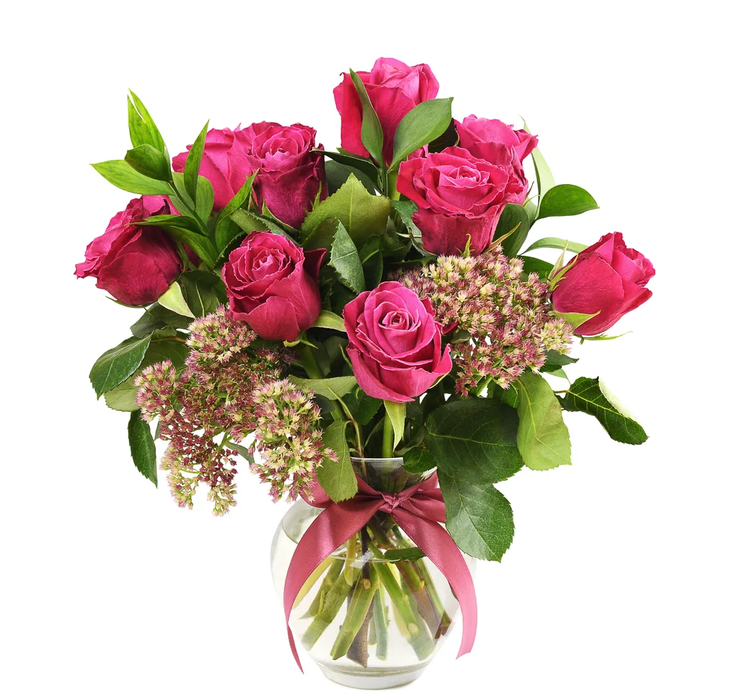 Pink roses in glass vase with ribbon