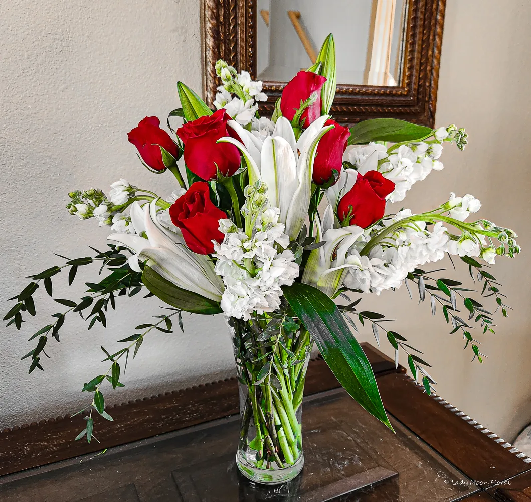 Vase with red roses and white lilies arrangement