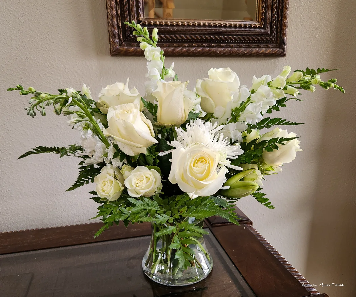 Elegant white flower bouquet in glass vase.